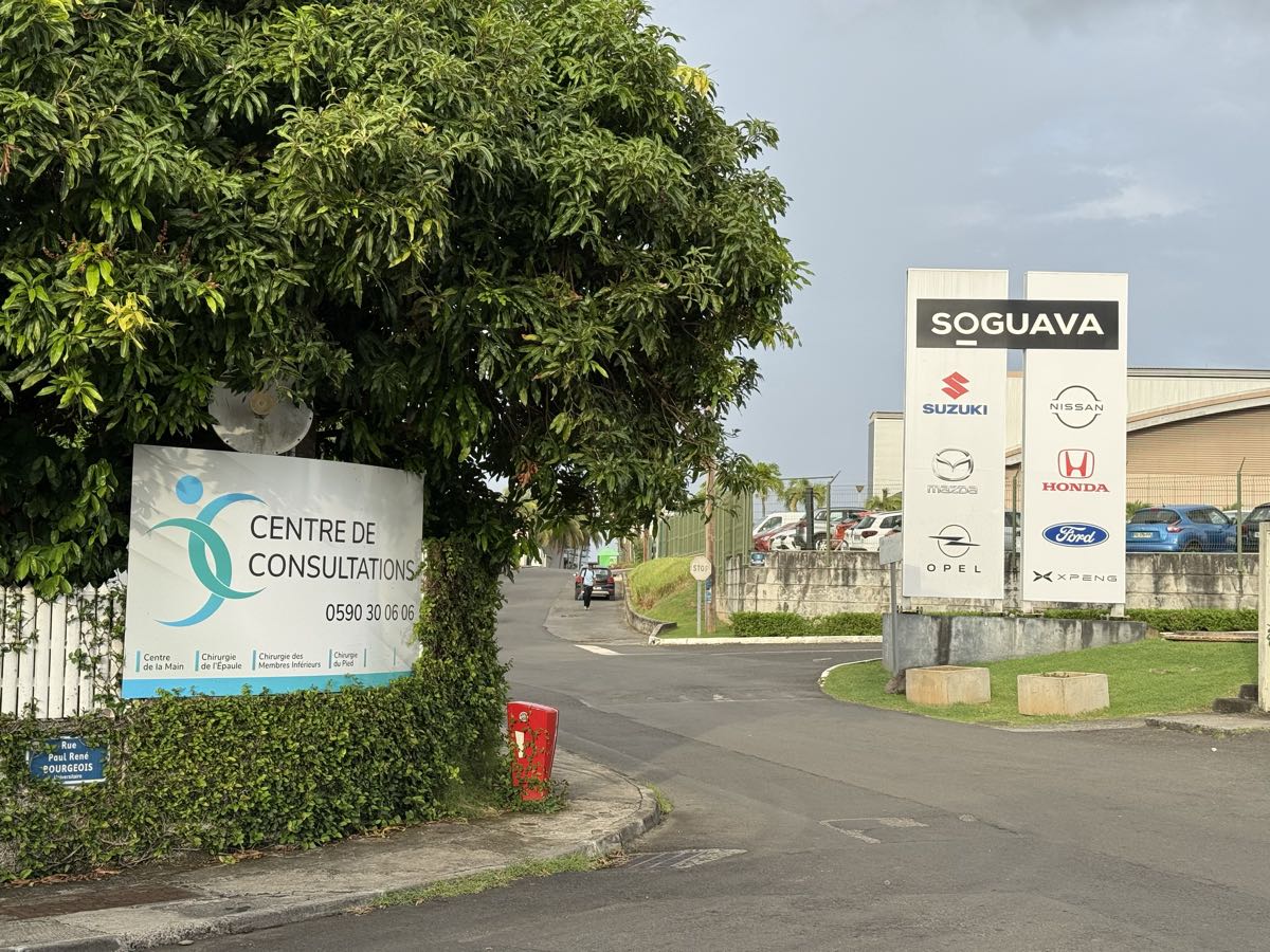 Le panneau du Centre de Consultation à gauche de la rue, face aux totems du garage SOGUAVA